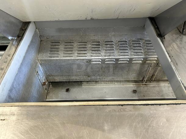 Continental Refrigerator SW60N24M-HGL prep table interior, showing metal surface and ventilation. Great condition, tested.