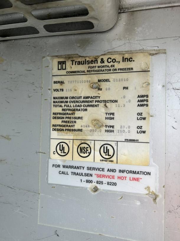 Traulsen G12010 freezer label detailing model, serial number T077110D98, 115V, UL and NSF certified, service hotline info.