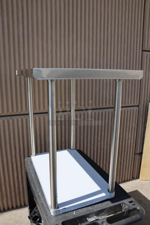 Brand new Regency 600TS2436S 24" x 36" 16-gauge stainless steel work table with undershelf, minor scratching visible.