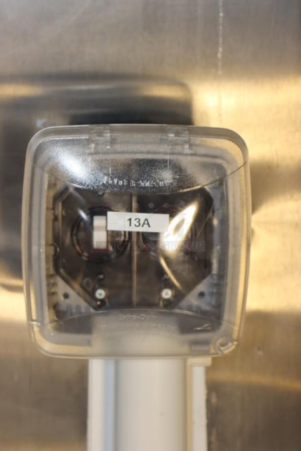 "13A" label on an electrical switch inside a Cruising Kitchens 24' food trailer, stainless steel interior.