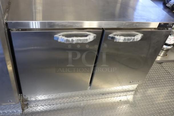 Stainless steel interior of a Cruising Kitchens 24' Enterprise Food Trailer, showing two new, wrapped handles.