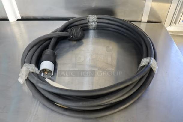 Coiled heavy-duty electrical cable on stainless steel surface, compatible with Cruising Kitchens food trailer hookups.