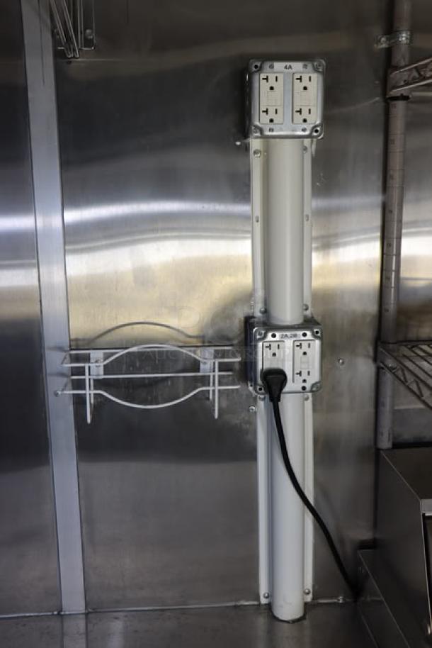 Interior view of the Cruising Kitchens 24' Enterprise Food Trailer featuring stainless steel walls and electrical outlets.