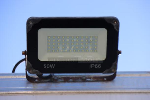 LED flood light, 50W, IP66, mounted on metal frame for outdoor use, part of the Cruising Kitchens food trailer equipment.