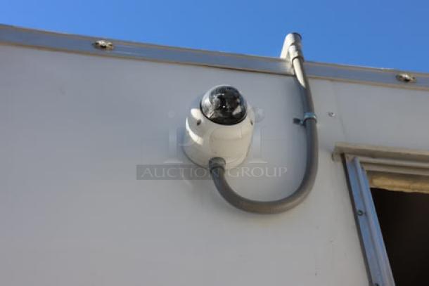 NEW Cruising Kitchens 24' food trailer with wireless security camera, featuring rooftop AC units, propane tanks, and LED lights.