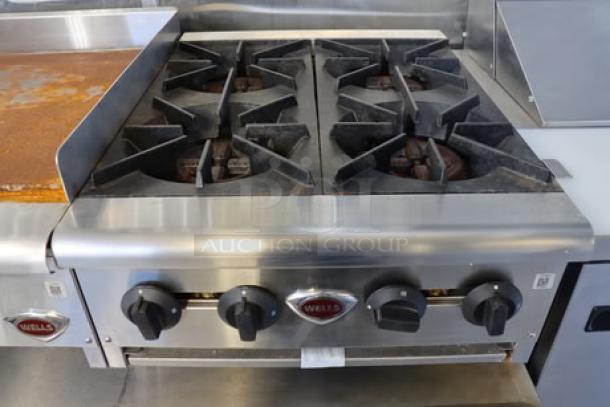 Stainless steel Wells gas range with four burners. Mint condition, part of Cruising Kitchens 24' Enterprise Food Trailer.