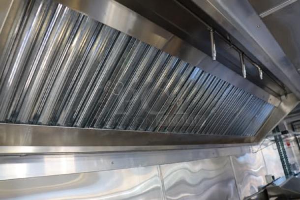 Cruising Kitchens 24' food trailer interior with stainless steel finish and rooftop grease filter. Fully equipped, new condition.