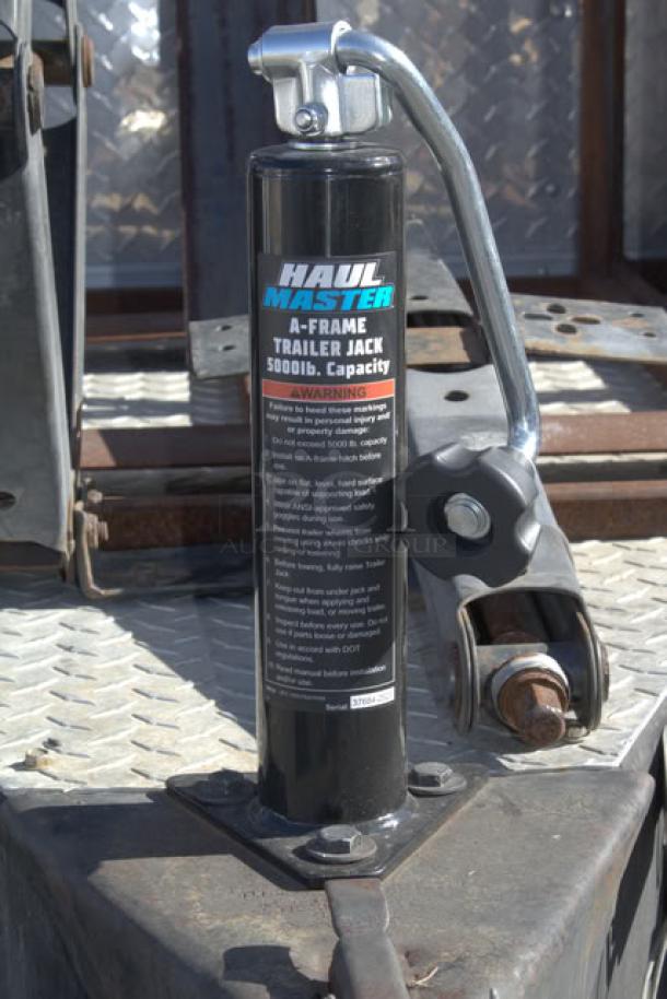 Haul-Master A-Frame trailer jack, 5000 lb. capacity, mounted on metal surface. Warning label visible on the side.