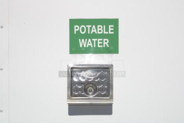 NEW Cruising Kitchens 24' food trailer with potable water hookup, stainless steel interior, wireless cameras, and rooftop AC.