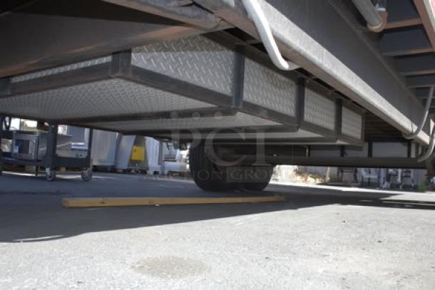 NEW Cruising Kitchens 24' food trailer undercarriage with durable construction and secure storage compartments.