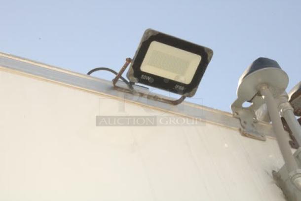 LED flood light on Cruising Kitchens 24' enterprise food trailer exterior with rooftop features visible.