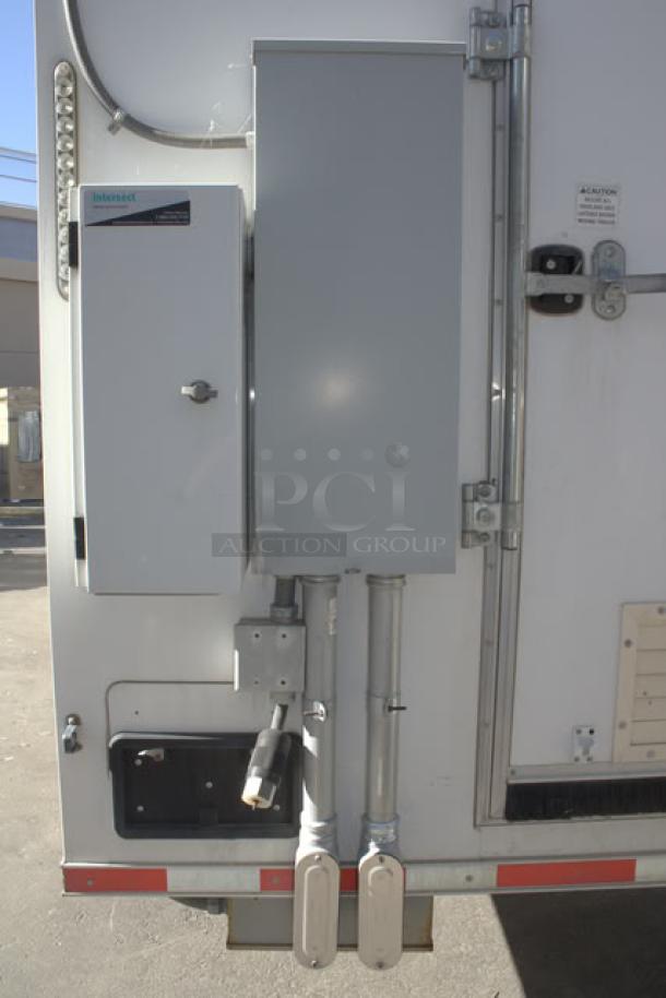 NEW Cruising Kitchens 24' food trailer, white, exterior features electrical hookup, propane connections, and security cameras.