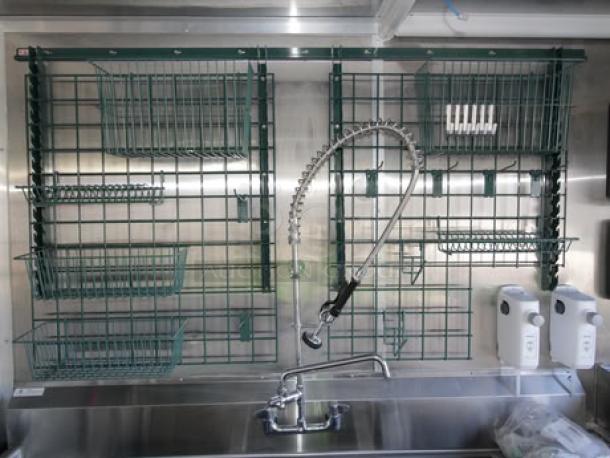 Inside view of a 2023 Cruising Kitchens mobile kitchen, featuring storage racks and a stainless steel sink with a spring faucet.