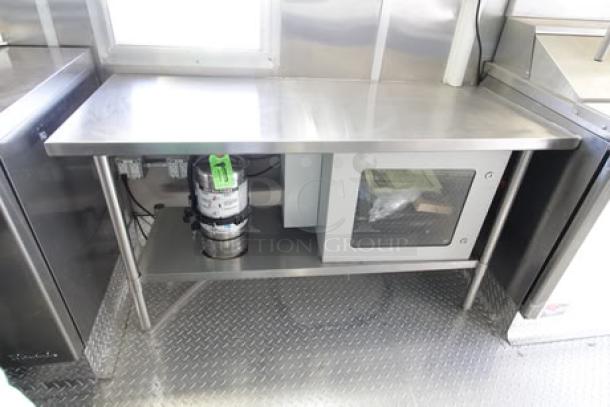 Brand new 2023 Cruising Kitchens 24 ft. food trailer interior, featuring stainless steel countertops and modern kitchen appliances.