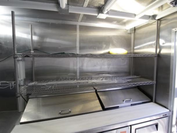 Brand new 2023 Cruising Kitchens 24 ft. food trailer interior; features stainless steel shelving and prep area.