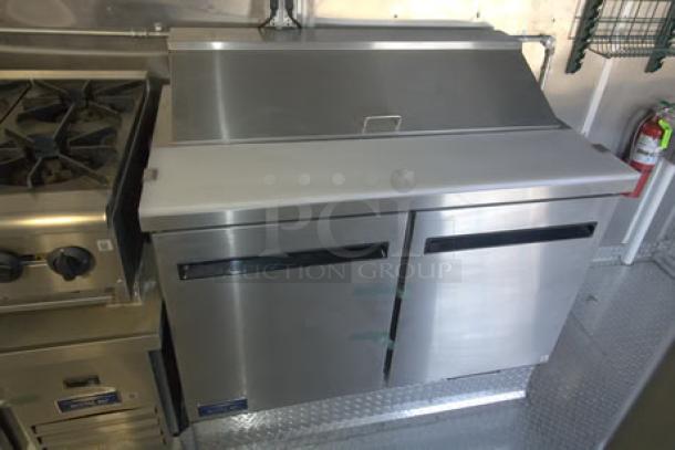 Brand new 2023 Cruising Kitchens 24 Ft. mobile kitchen with stainless steel appliances, including range and refrigeration unit.