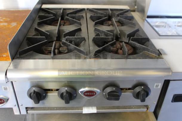 Wells four-burner commercial gas range in stainless steel, part of the 2023 Cruising Kitchens food trailer setup.