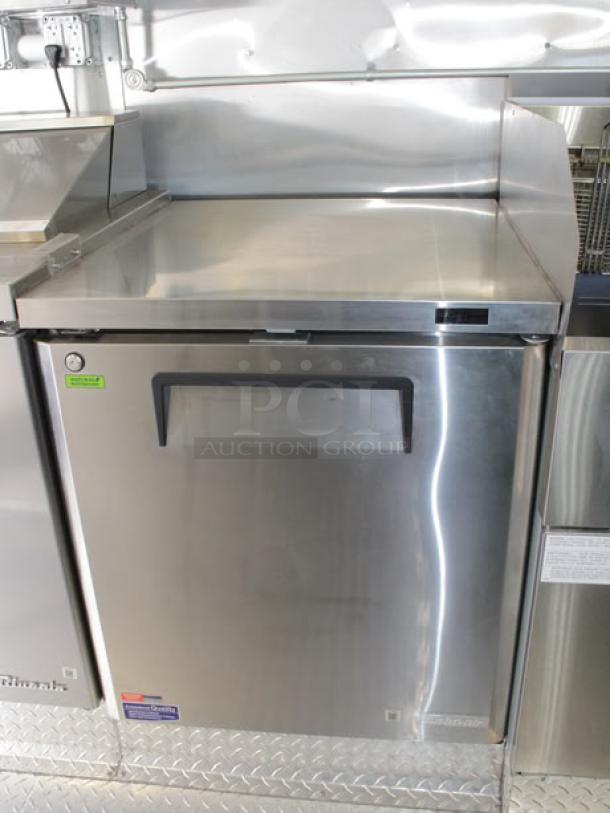 Stainless steel commercial-grade cooler in new condition inside a 2023 Cruising Kitchens food trailer.