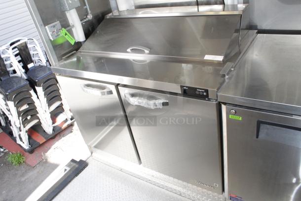 Brand new 2023 Cruising Kitchens 24 ft food trailer interior, featuring stainless steel commercial appliances and storage.