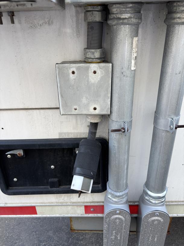 Electrical hookup for Cruising Kitchens 2023 Enterprise Food Trailer, showing power options with visible metal conduit and connectors.