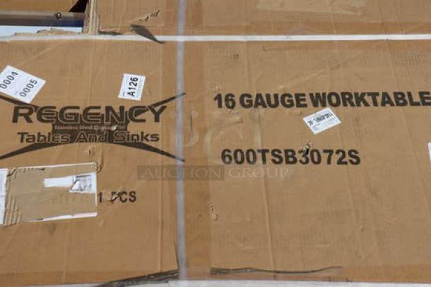 Cardboard box labeled with "Regency 16 Gauge Worktable," model 600TSB3072S, containing a new stainless steel work table.