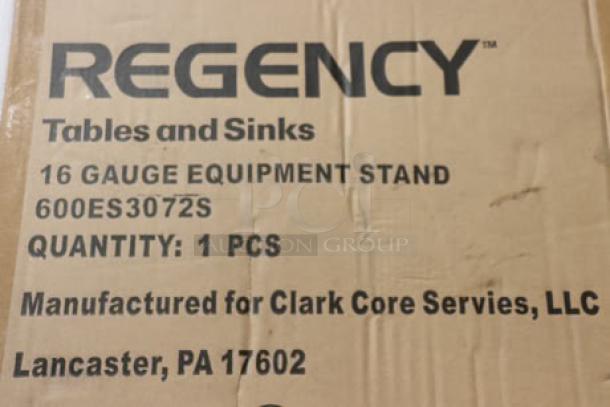 Cardboard box with label for Regency 600ES3072S 16-gauge stainless steel equipment stand; box shows minor damage.