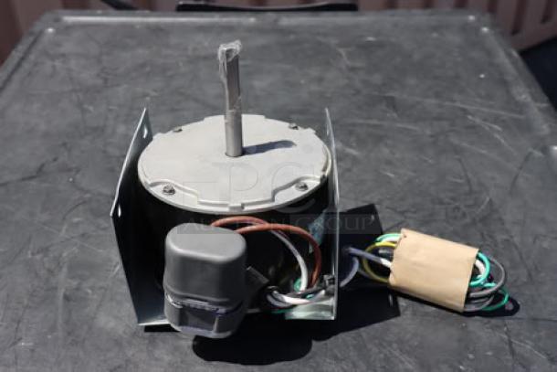 BRAND NEW Manitowoc Ice 7629413 fan motor, Magnetek 208-230v. Slightly bent mounting bracket visible.