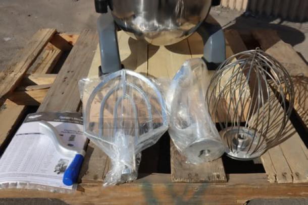 Brand new Vollrath 40757 20 Qt. planetary stand mixer, shown with guard and standard accessories, includes dough hook, flat beater, and wire whip.