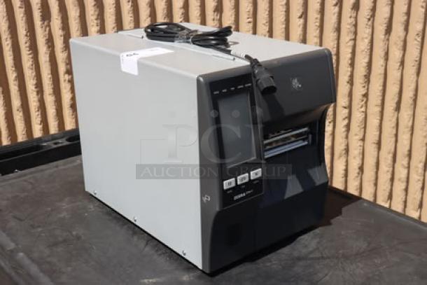 Zebra ZT411 industrial barcode printer, model ZT41142-T410000Z. Serial number 99J242802106. Features include a control panel and connectivity ports.