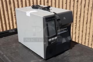 Zebra ZT411 industrial barcode printer, model ZT41142-T410000Z. Serial number 99J242802106. Features include a control panel and connectivity ports.
