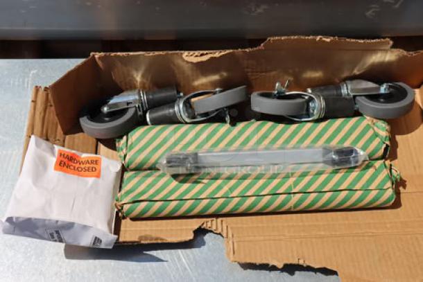 Unassembled Eagle Group PCP-4 mobile cold food table parts, including casters and hardware, in original packaging.