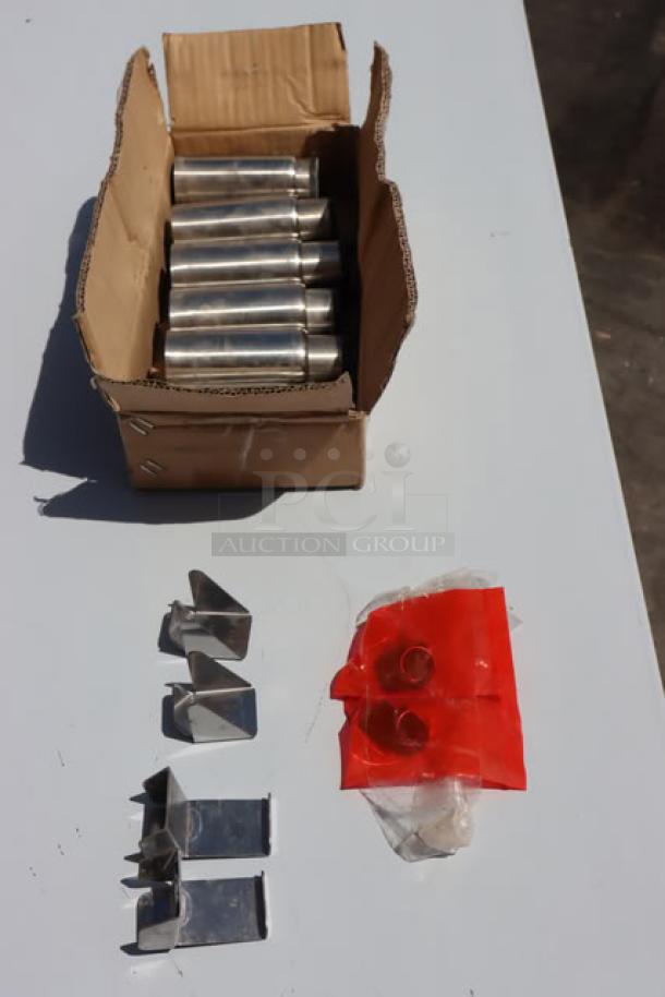 Box of metal components and fasteners, likely for assembly, on a white surface. Includes metal legs and brackets in packaging.