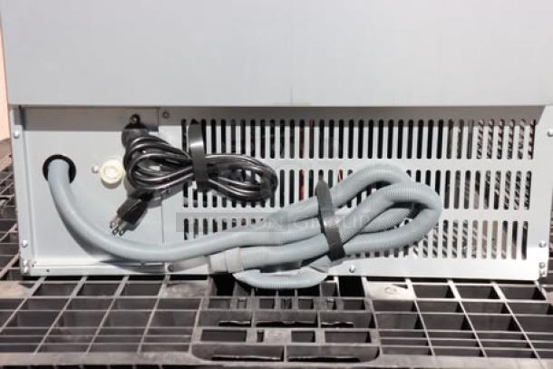 Hoshizaki AM-50BAJ undercounter ice machine, air-cooled, 51 lb capacity, dented top, with power cord and hose attached.