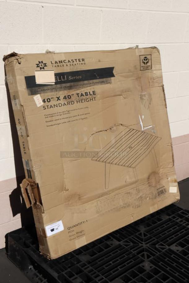 Damaged packaging of Lancaster Virelli 40x40 Tigerwood outdoor table. Item is new; box shows scratches and dents.