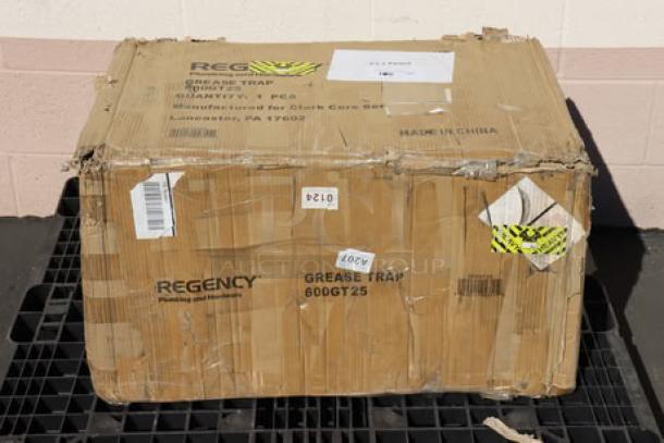Regency 600GT25 50 lb. 25 GPM grease trap, non-threaded connections, box damaged, tags show model and shipping details.