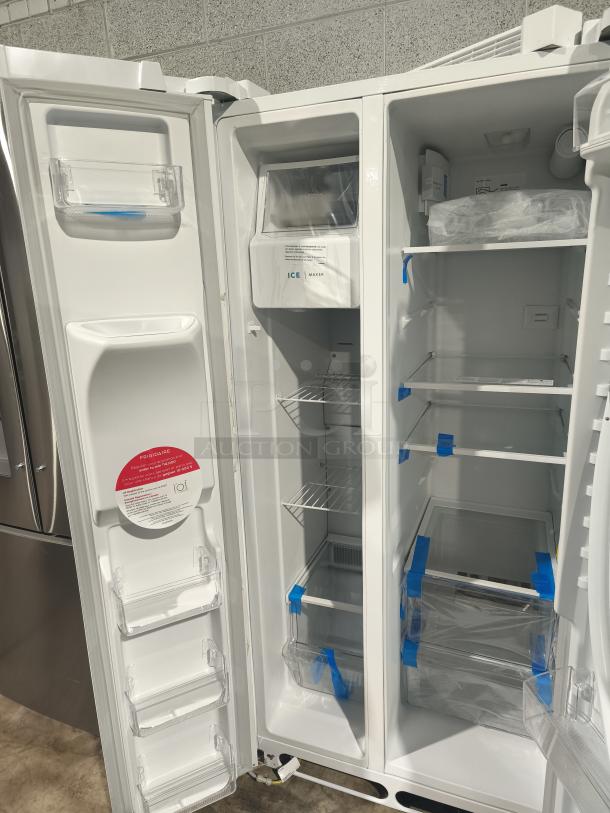 Frigidaire 22.3 Cu. Ft. side-by-side fridge, model FRSS2323AW, new with minor scratches, open doors showing interior shelves.