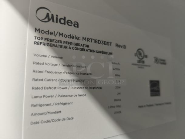 Midea 18.1 cu ft top-freezer refrigerator, model MRT18D3BST, new condition. Label shows technical details.