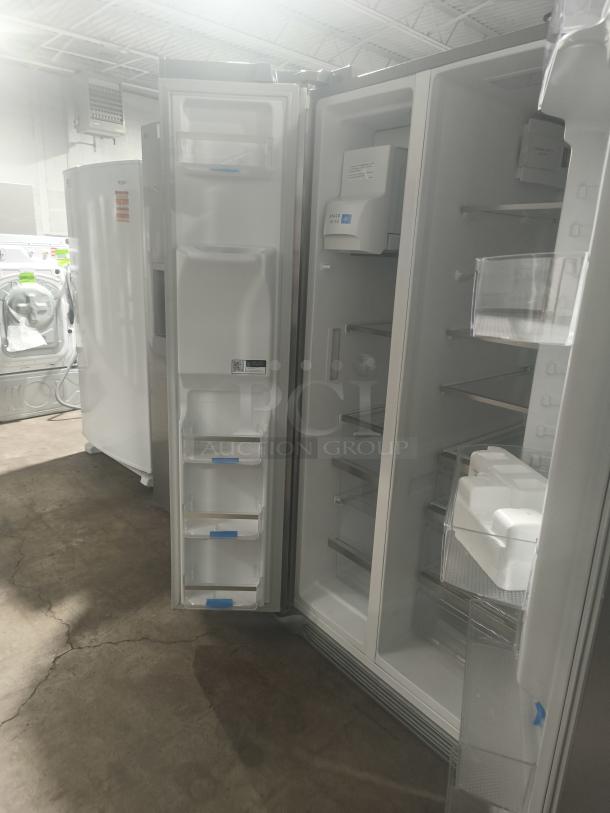 NEW Frigidaire Gallery 25.6 cu ft side-by-side refrigerator, model GRSS2652AFA, with open doors showing shelves and compartments.