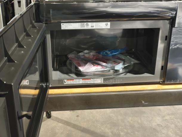 Brand new GE Profile 2.1 cu ft over-the-range microwave oven, model PVM9005SJ8SS, with visible packaging inside.