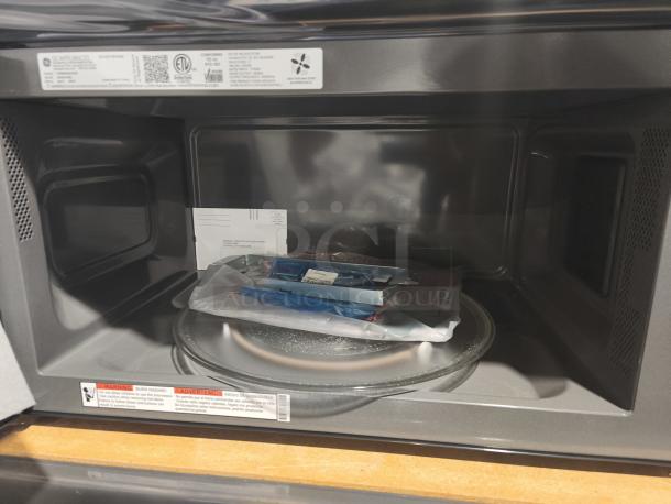 BRAND NEW GE Profile Microwave Model PVM9005SJ8SS; 2.1 cu ft, over-the-range, sensor cooking, minor scratch and dent, tags visible.