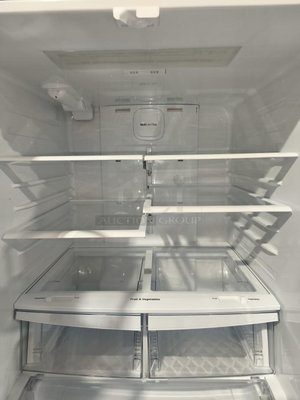 Interior view of a new LG 21.8 cu ft 3-Door French Door Refrigerator, Model LFDS22520S/06, showcasing multi-shelf design with drawers.