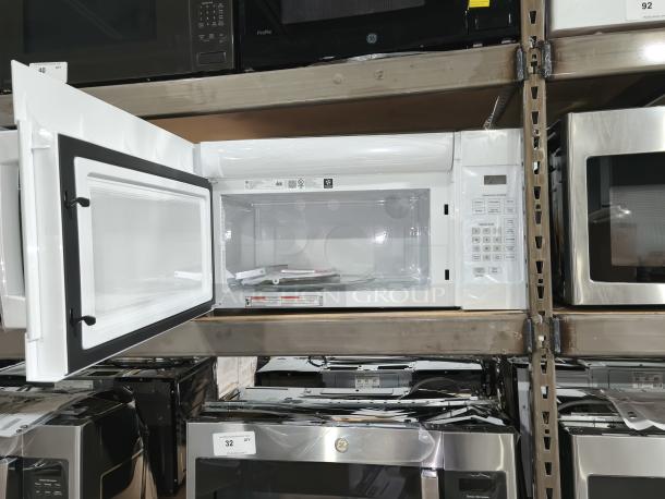 NEW GE 1.6 cu ft Over-the-Range Microwave Oven, model JVM3160DF9WW, white, open door, keypad, pristine condition.