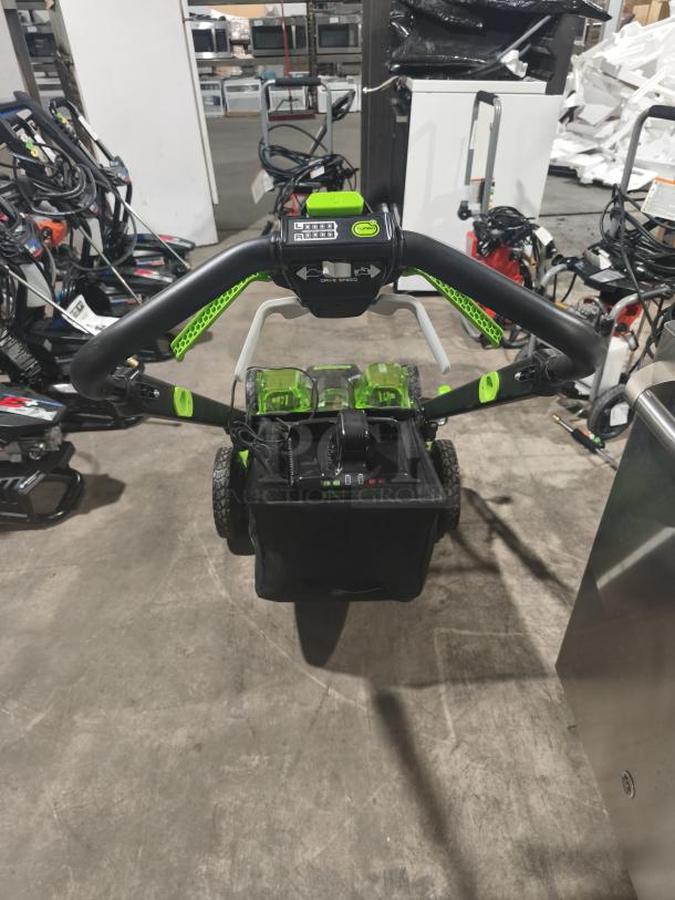 Greenworks 80V 25" self-propelled cordless mower, model LMB405, tested and working. Features dual batteries and ergonomic controls.