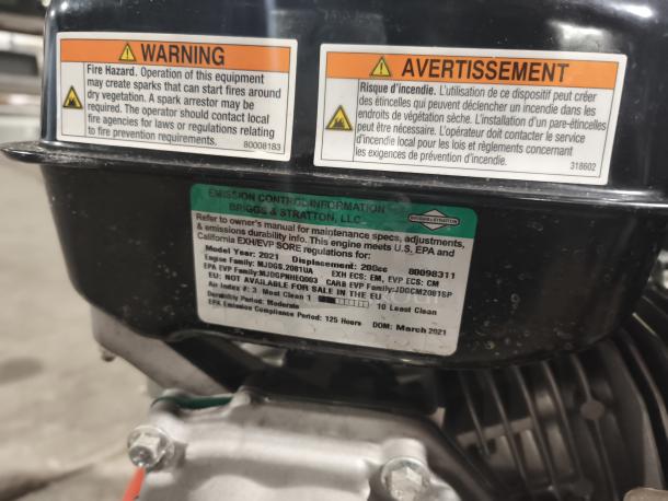 Husqvarna HB32 pressure washer engine close-up with warning and emission labels, 2021 model, in working condition.