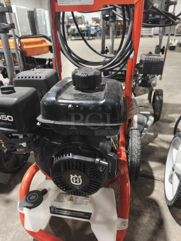 Husqvarna PW 3200 PSI pressure washer, tested and working, sturdy frame, visible branding, black and orange design, excellent condition.