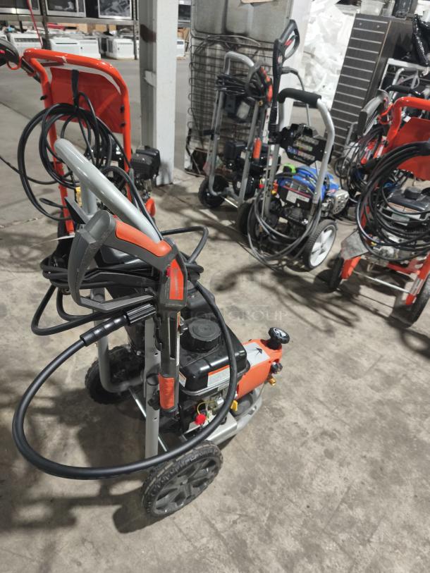 Husqvarna PW-3200 gas pressure washer, model 022007, with sturdy wheels and handle, shown in working condition.