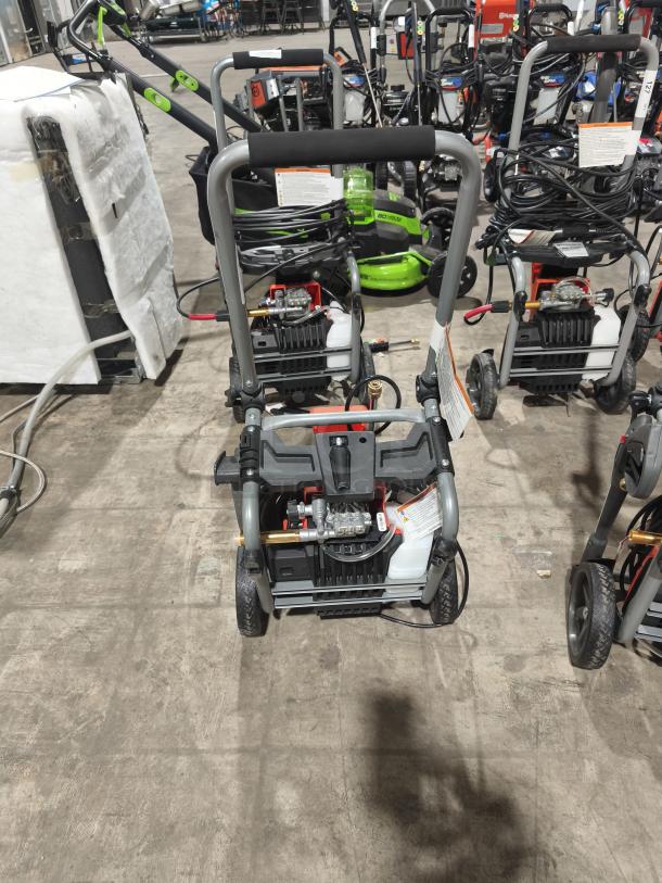 Husqvarna PW2300 electric pressure washer, tested, working condition. Features durable wheels, hose reel, and ergonomic handle.