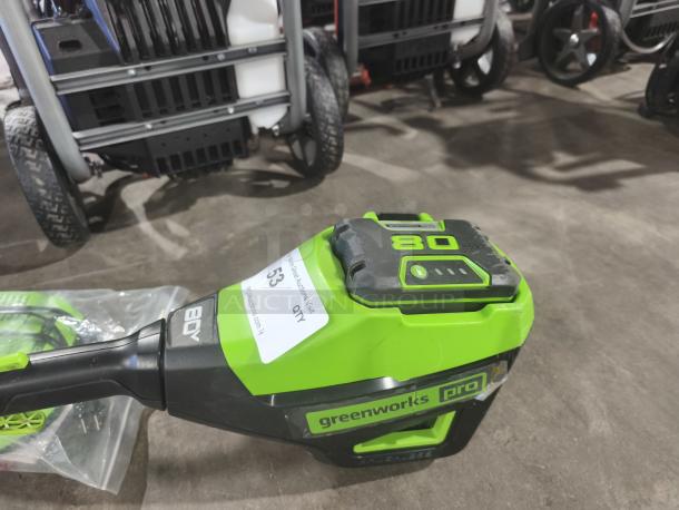 Greenworks Pro STB409 80V cordless string trimmer, tested and working, 16-inch, visible battery pack, auction tag present.