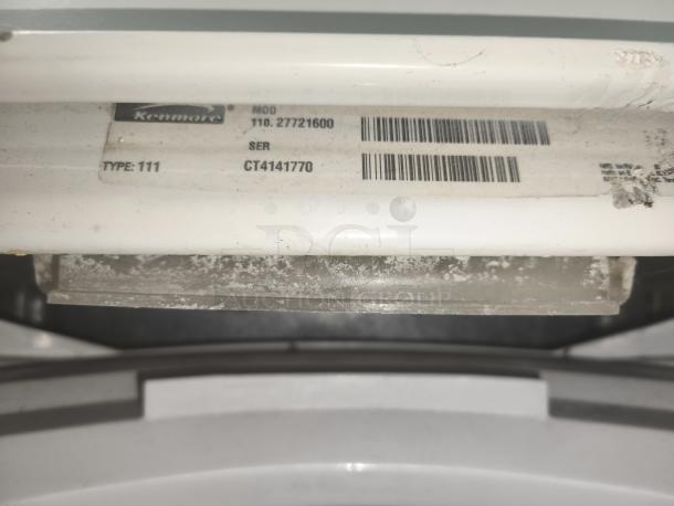 Kenmore top-load washing machine, model 11027721600. Visible label showing model and serial number. Signs of use.