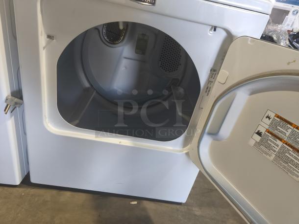 Maytag MEDX655DW1 7.0 cu ft electric dryer, open door view, showing interior and control labels. Features Sanitize Cycle.